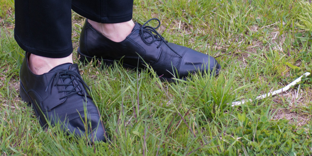 黒いスニーカーと黒いスラックス