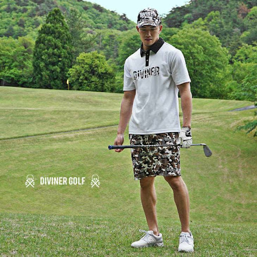 モノトーンのシャツに迷彩柄のパンツを着てゴルフをする男性